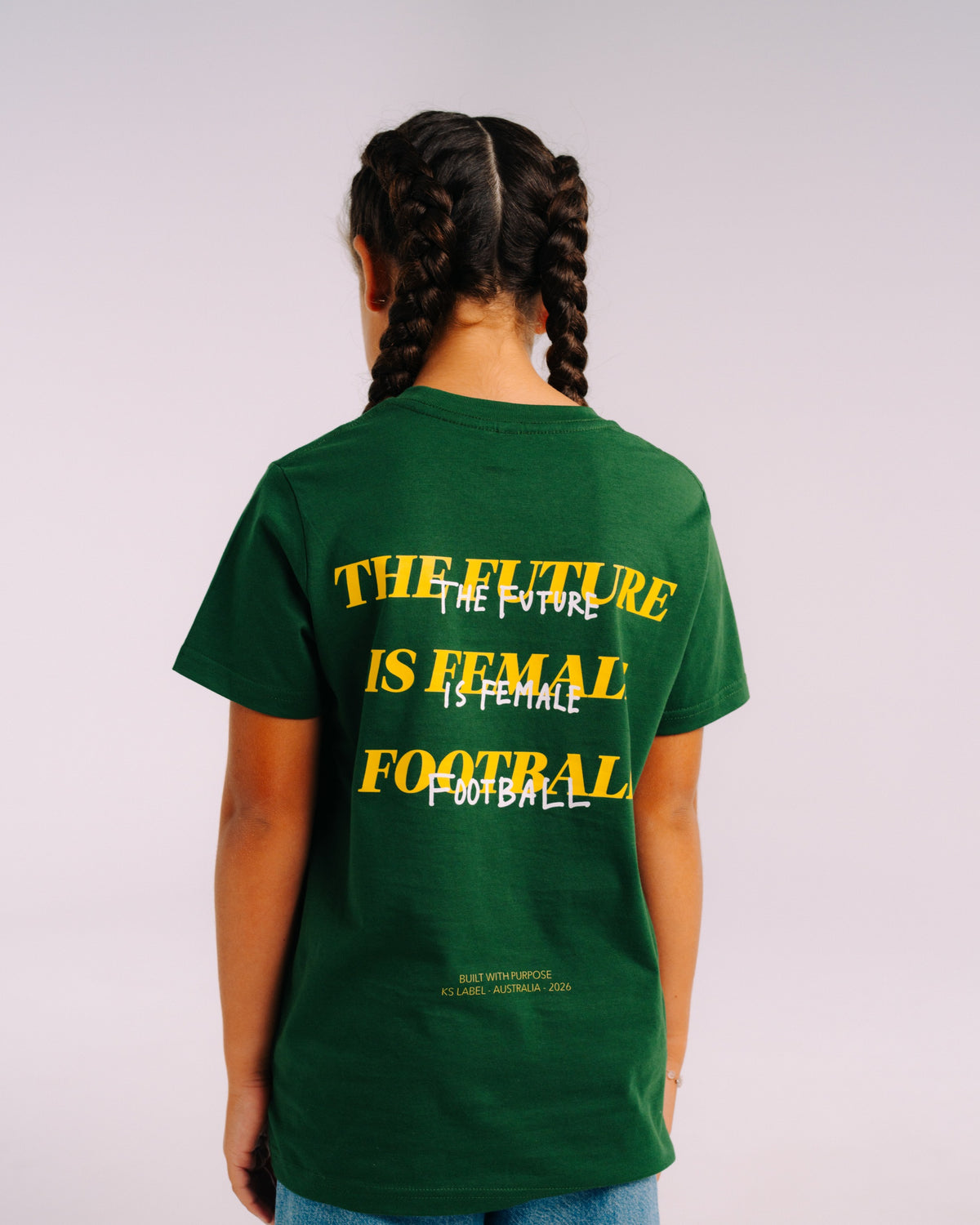 Her Era Statement Youth tee in Core Green, worn in studio, back view showing The Future Is Female Football print – KS Label