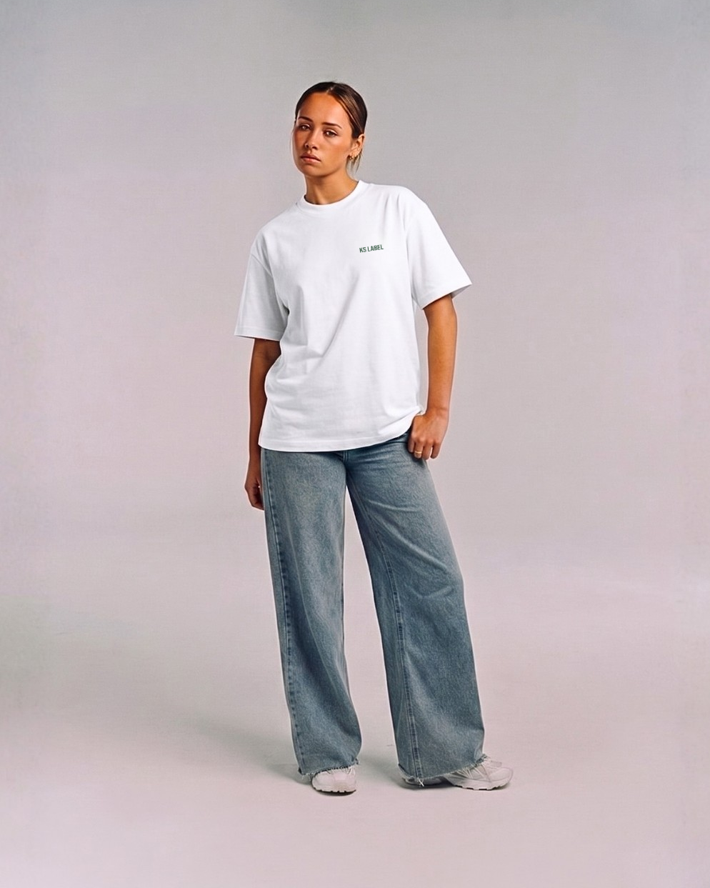 Model wearing the front of the white SHE CAN Tee by KS Label
