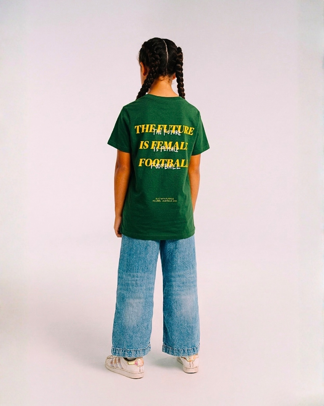 Model wearing the back of the green Her Era Statement Youth tee by KS Label