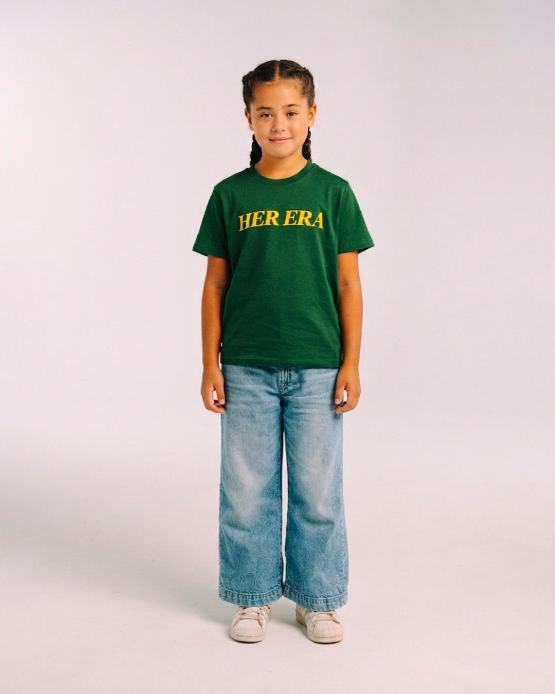 Model wearing the front of the green Her Era Statement Youth tee by KS Label