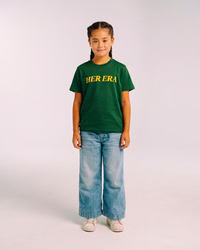 Model wearing the front of the green Her Era Statement Youth tee by KS Label