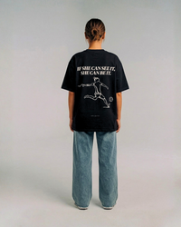 Model wearing the back of the black SHE CAN Tee by KS Label