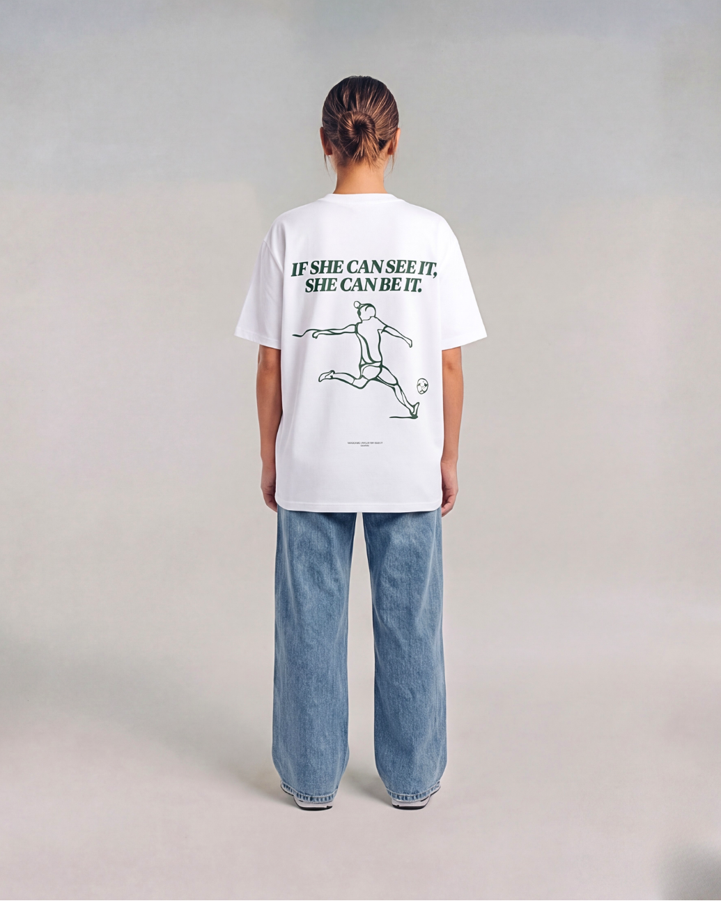 Model wearing the back of the white SHE CAN Tee by KS Label