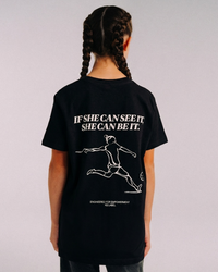 Close view of a model wearing the back of the black SHE CAN Youth tee by KS Label